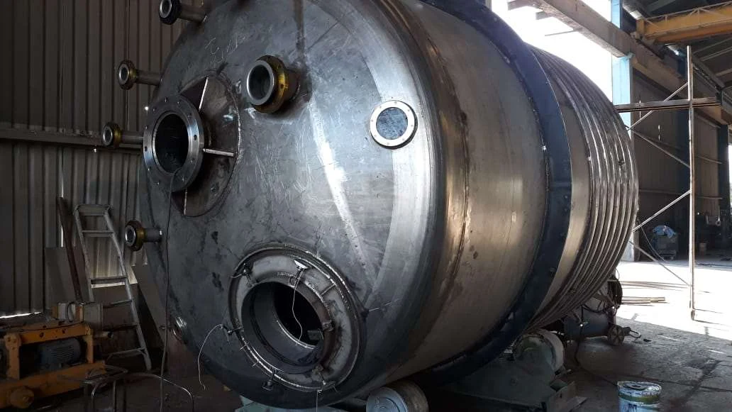 Stainless steel stirred reactor tank with serpentine coil for the chemical industry.